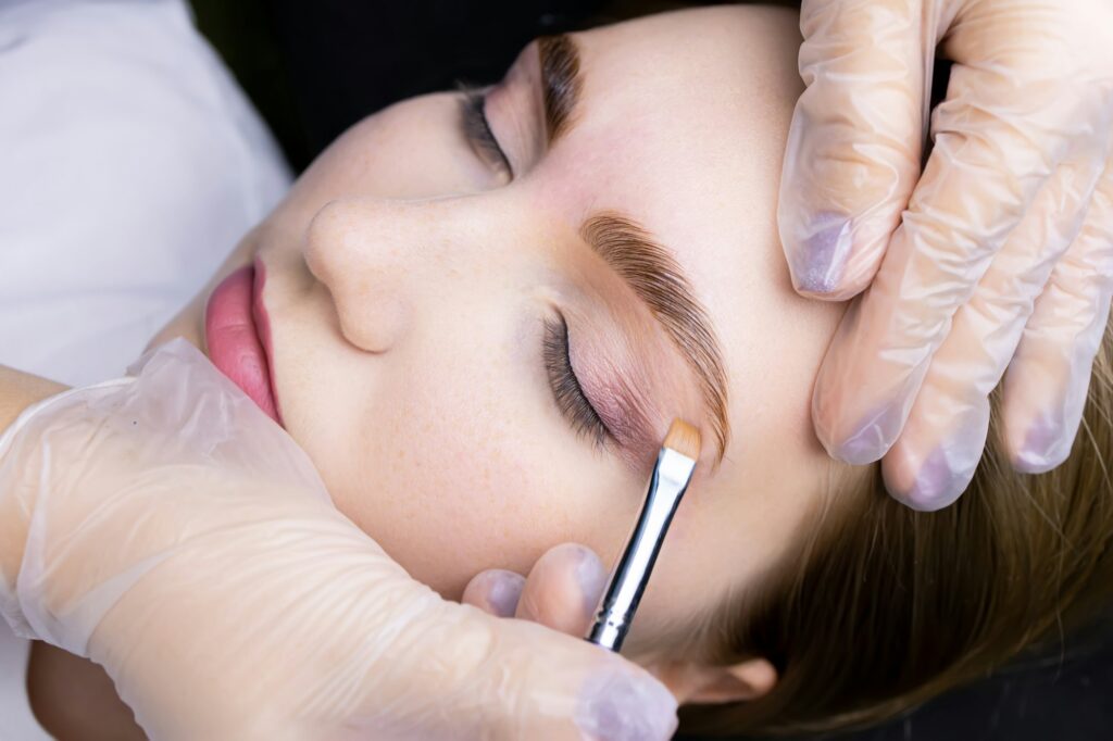 the eyebrow after the lamination procedure, the master applies a toning agent with a brush